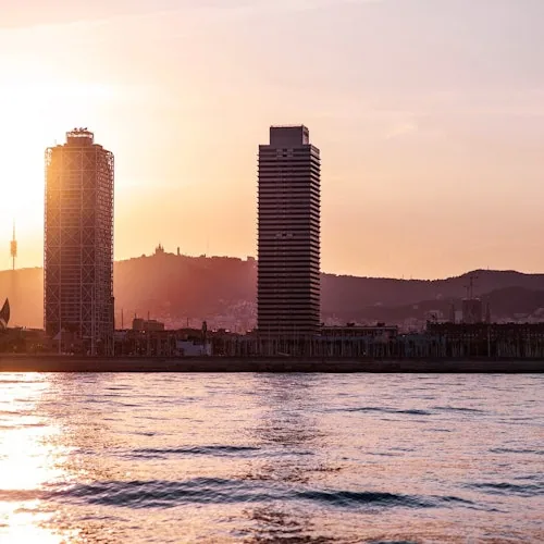 Barcelona waterfront towers viewed from the sea at sunset