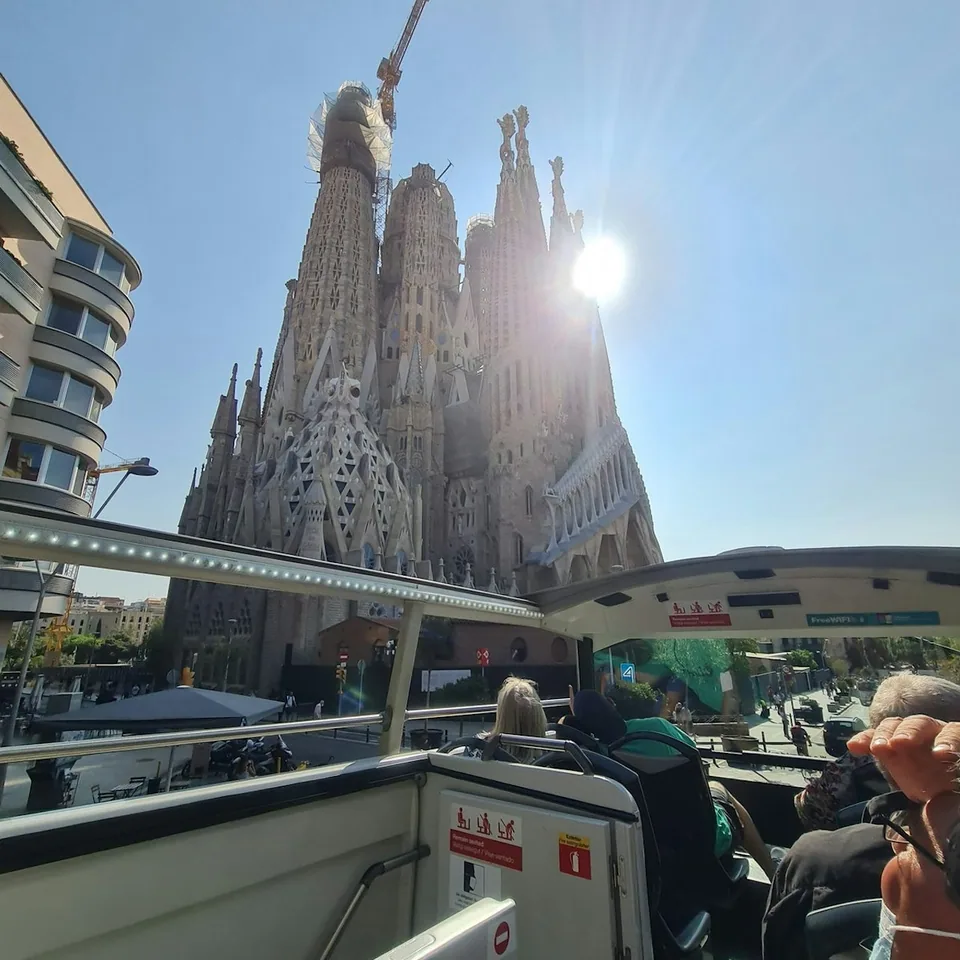Sightseeing bus passengers passing Sagrada Família in Barcelona