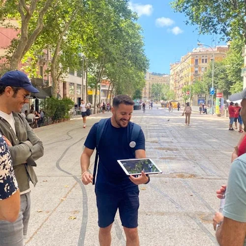 Guide and visitors walking along a tree-lined Barcelona promenade