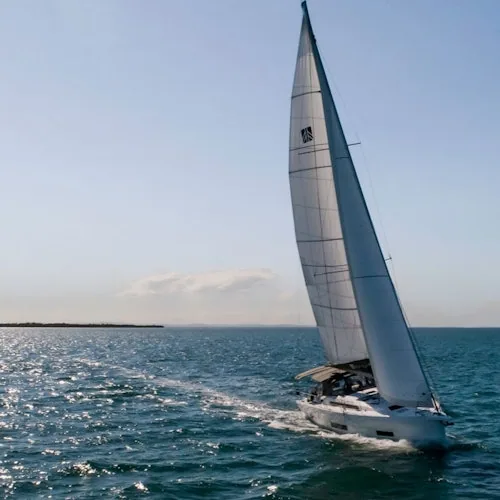 Yacht with raised sails off the Barcelona coastline