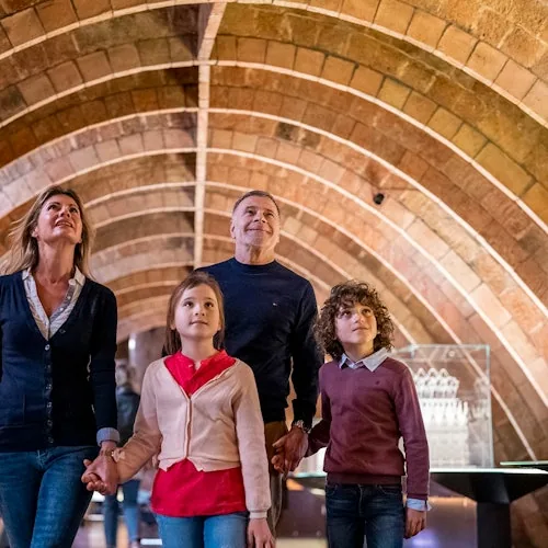 Family walking beneath brick arches in La Pedrera’s attic