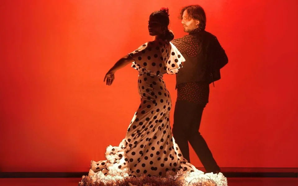 Two dancers in red and polka-dot costumes at City Hall Flamenco