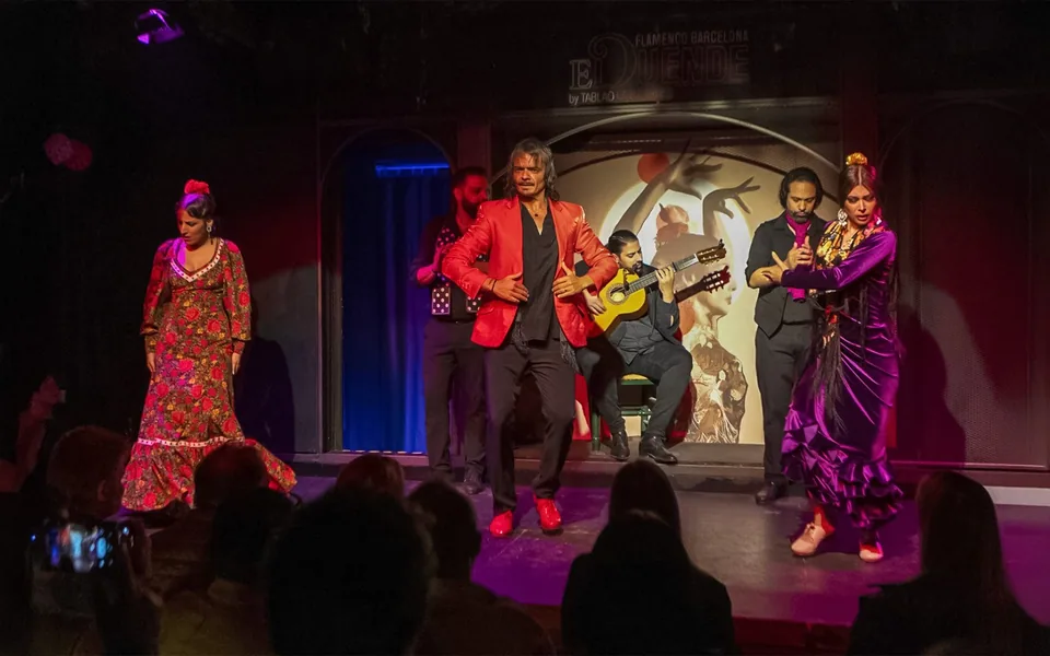 Two flamenco dancers performing with musicians at El Duende