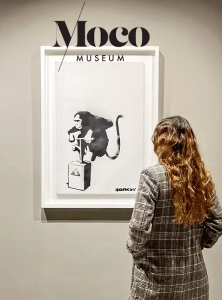 Besucher neben einer farbenfrohen Kunstinstallation im Moco Barcelona