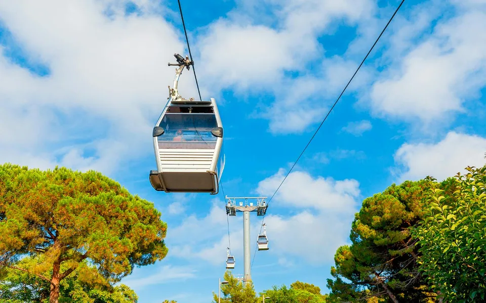 Montjuïc Cable Car cabin suspended above hillside trees