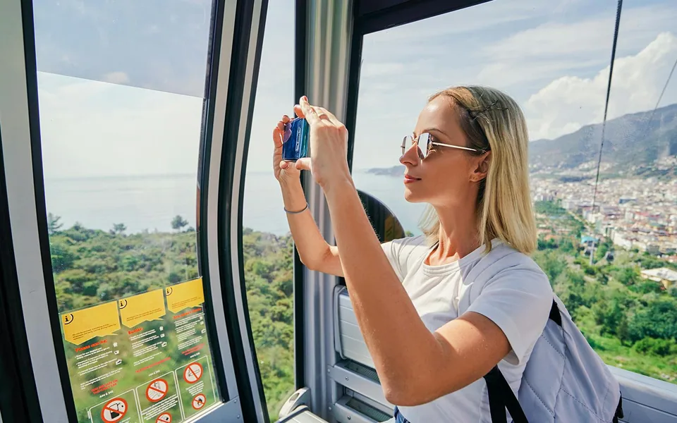 Visitor photographing Barcelona from a cable-car cabin