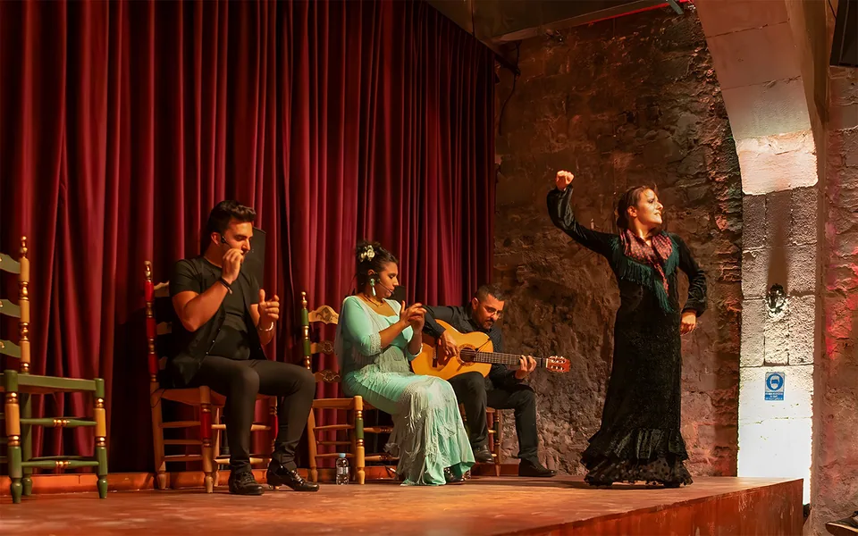 Flamenco ensemble performing beneath brick arches at Palau Dalmases