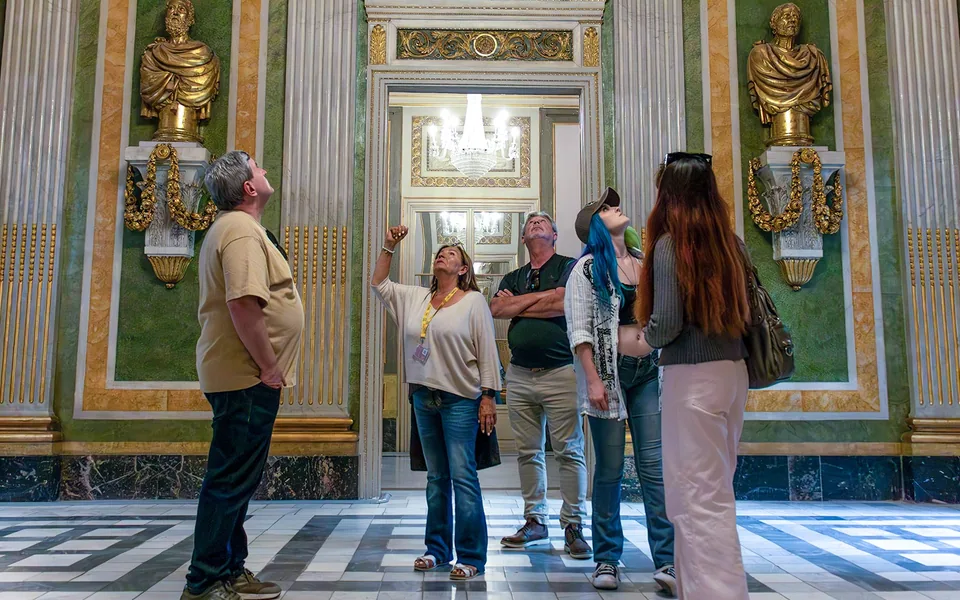 Guide and visitors beside decorated stone walls during a Barcelona cultural tour