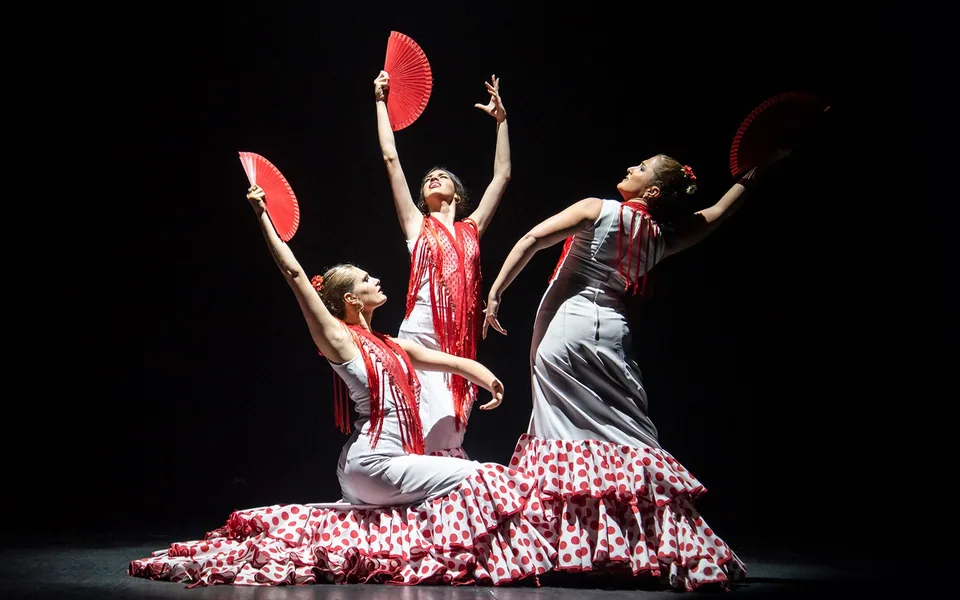 Two flamenco performers holding fans on stage